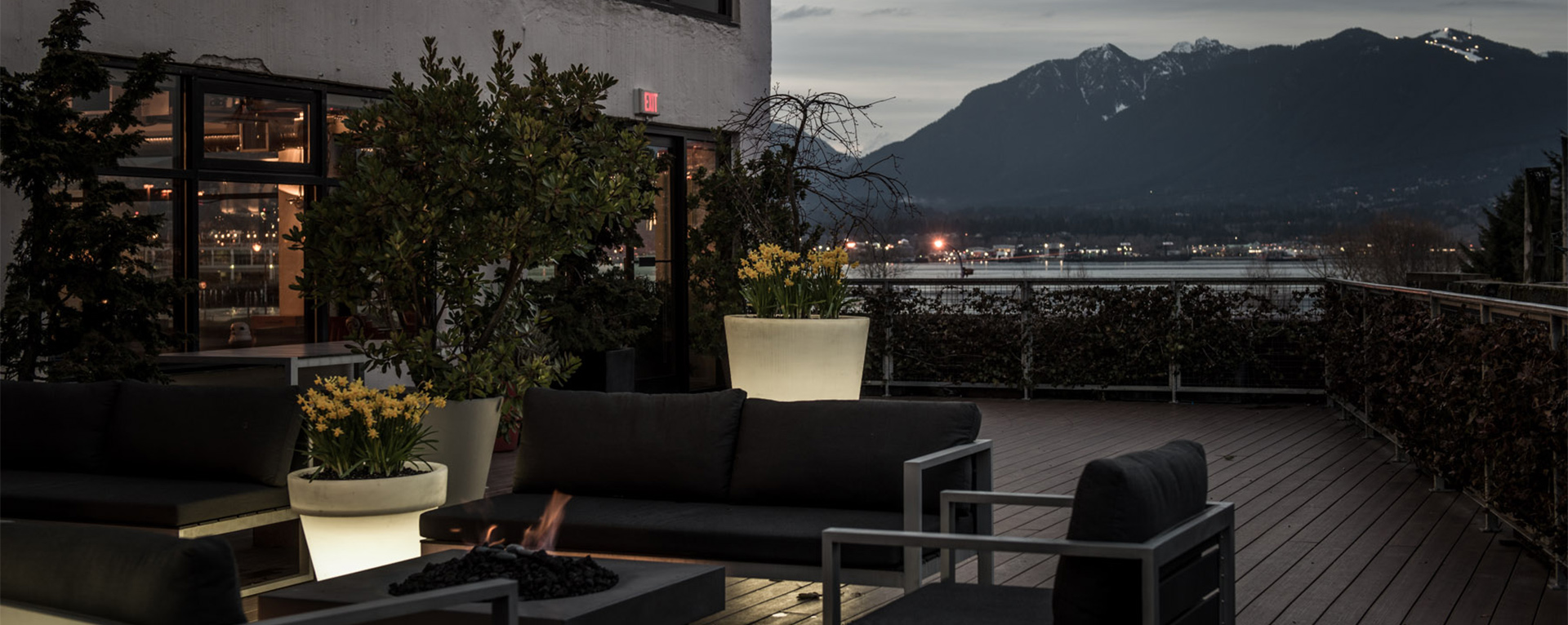 A nighttime view of the employee outdoor sitting area with a view of the mountains in the background