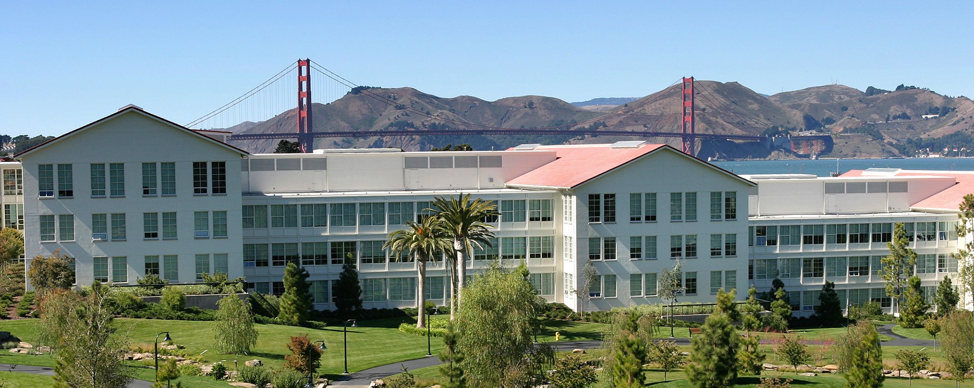 A wide view of the Letterman Digital Arts Center in the Presidio of San Francisco, California, with the Golden Gate Bridge, San Francisco Bay, Golden Gate Bridge, and Marin Headlands in the background