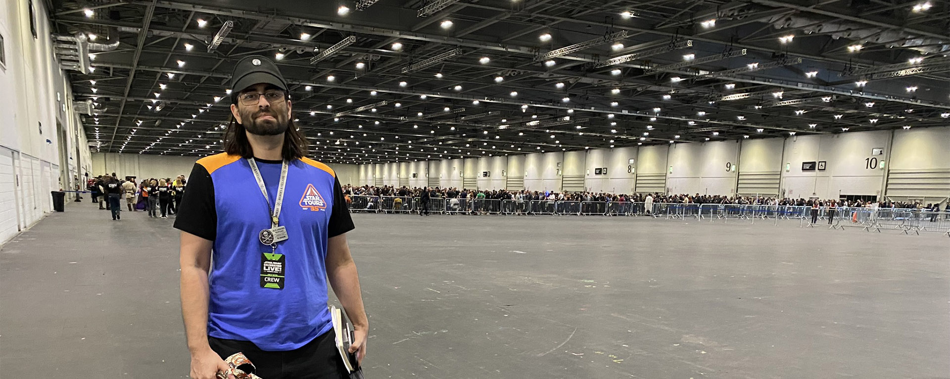 Lucasfilm's Alex Vargas standing before the long queues within London ExCel for Star Wars Celebration 2023