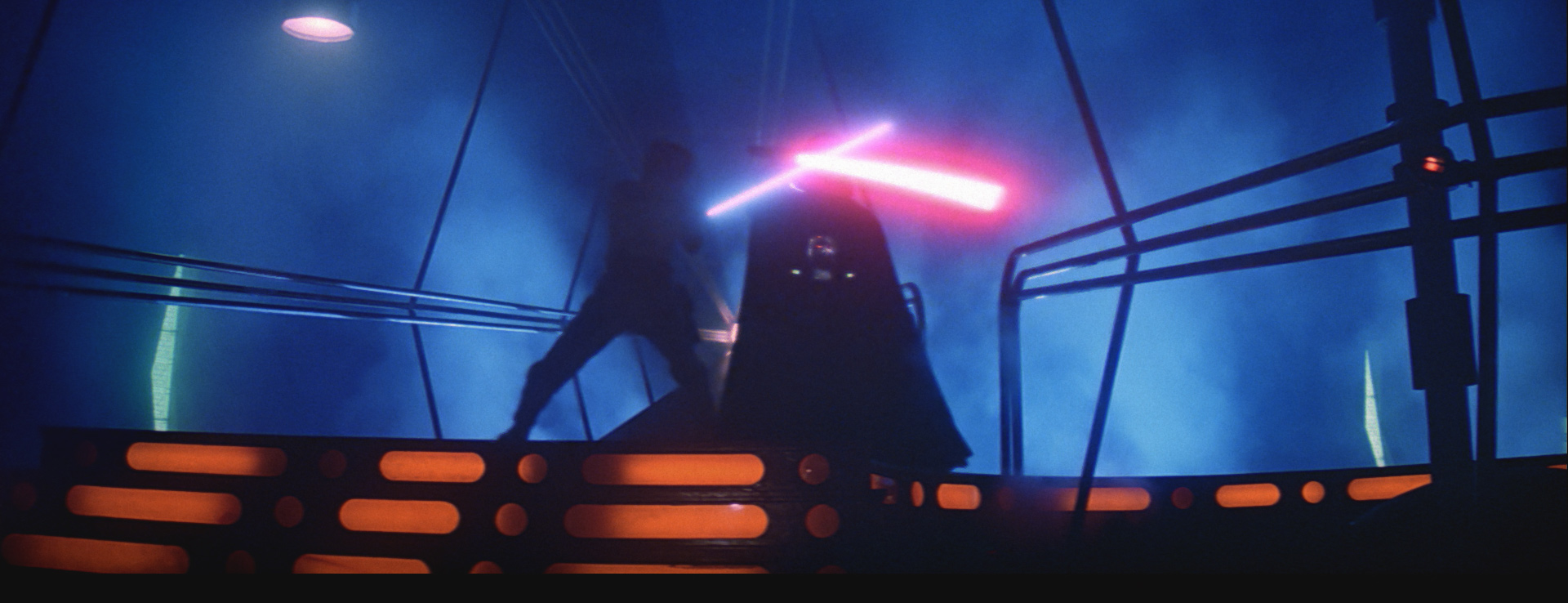 A film still from Star Wars: Return of the Jedi featuring Luke and Darth Vader on the Death Star crossing lightsabers.