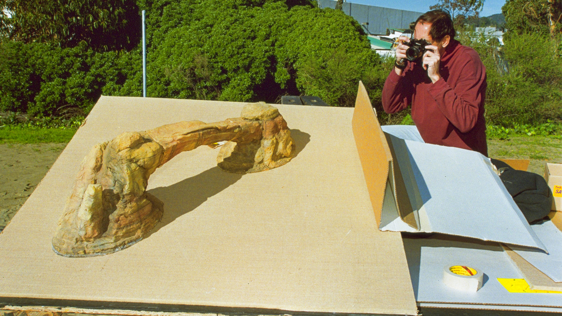 Artist Paul Huston photographs a rock arch miniature.