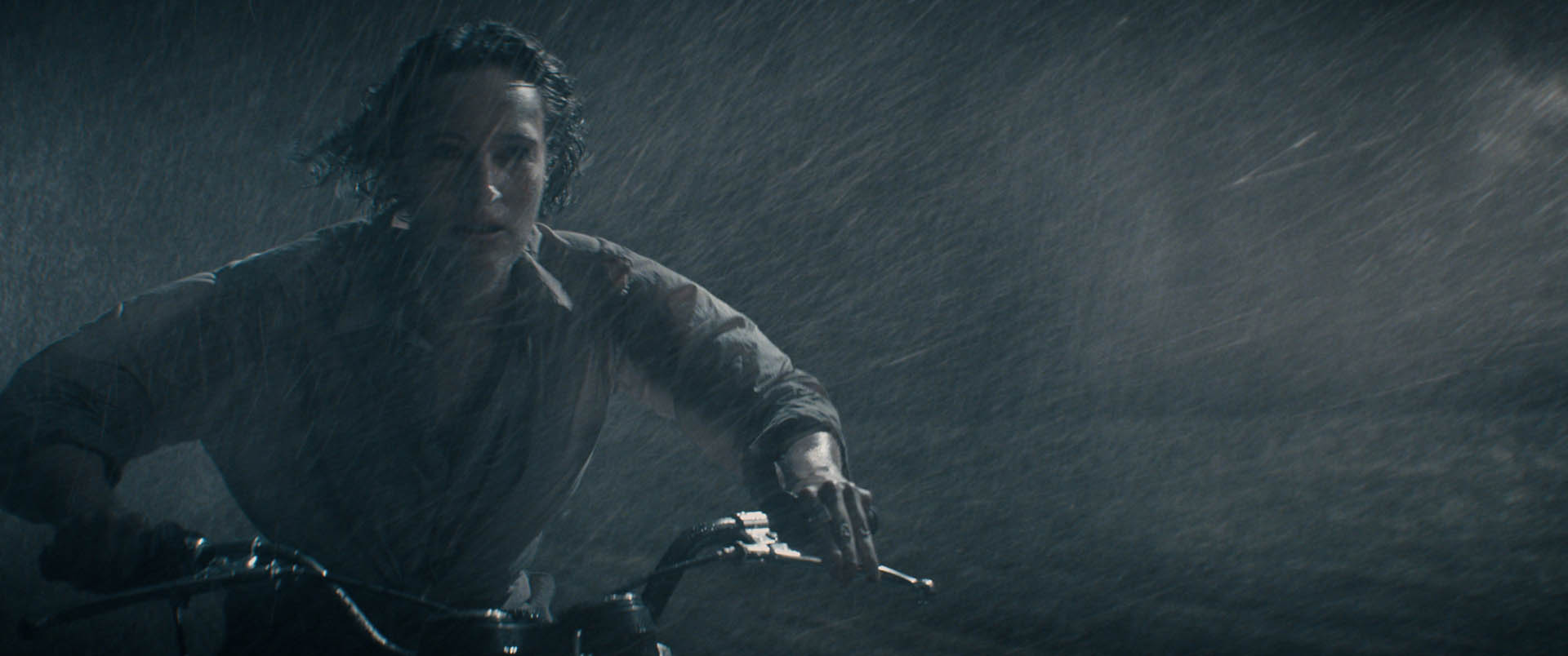 Helen on the motorbike chasing the plane in the driving rain at night.