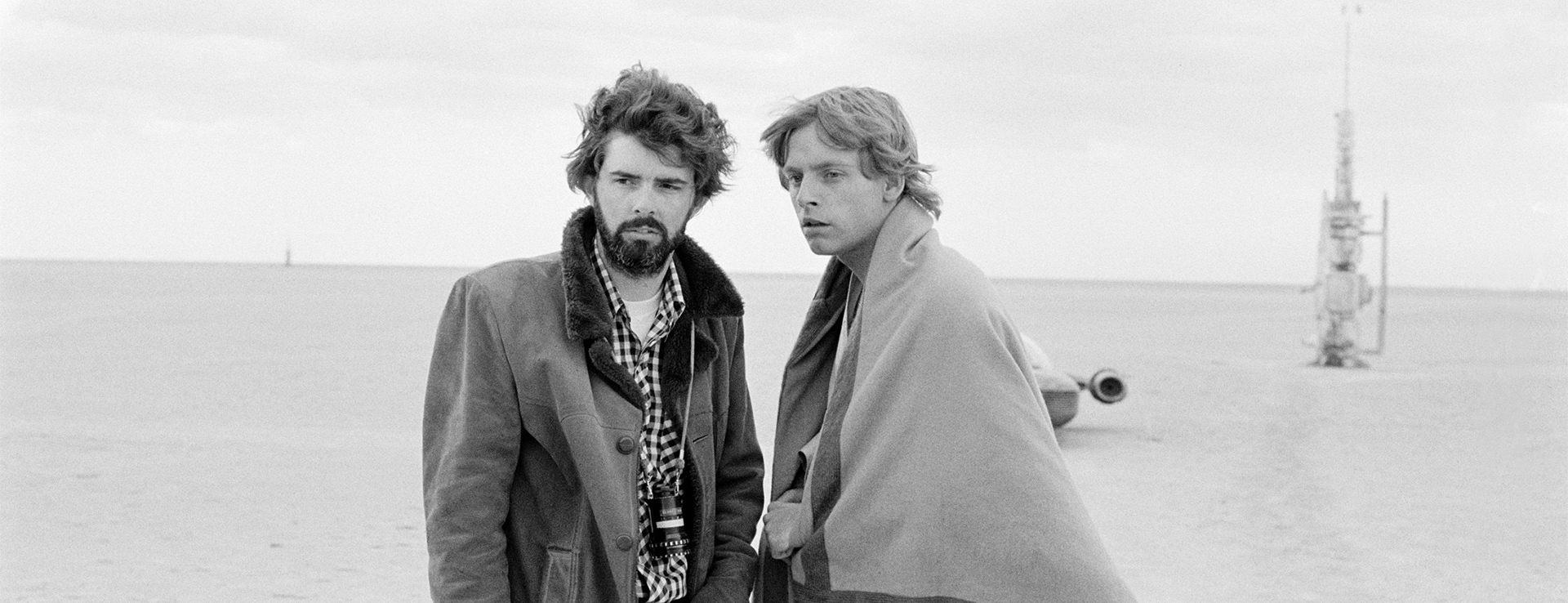 George Lucas and Mark Hamill standing on the Lars Homestead set in Tunisia for Star Wars: A New Hope